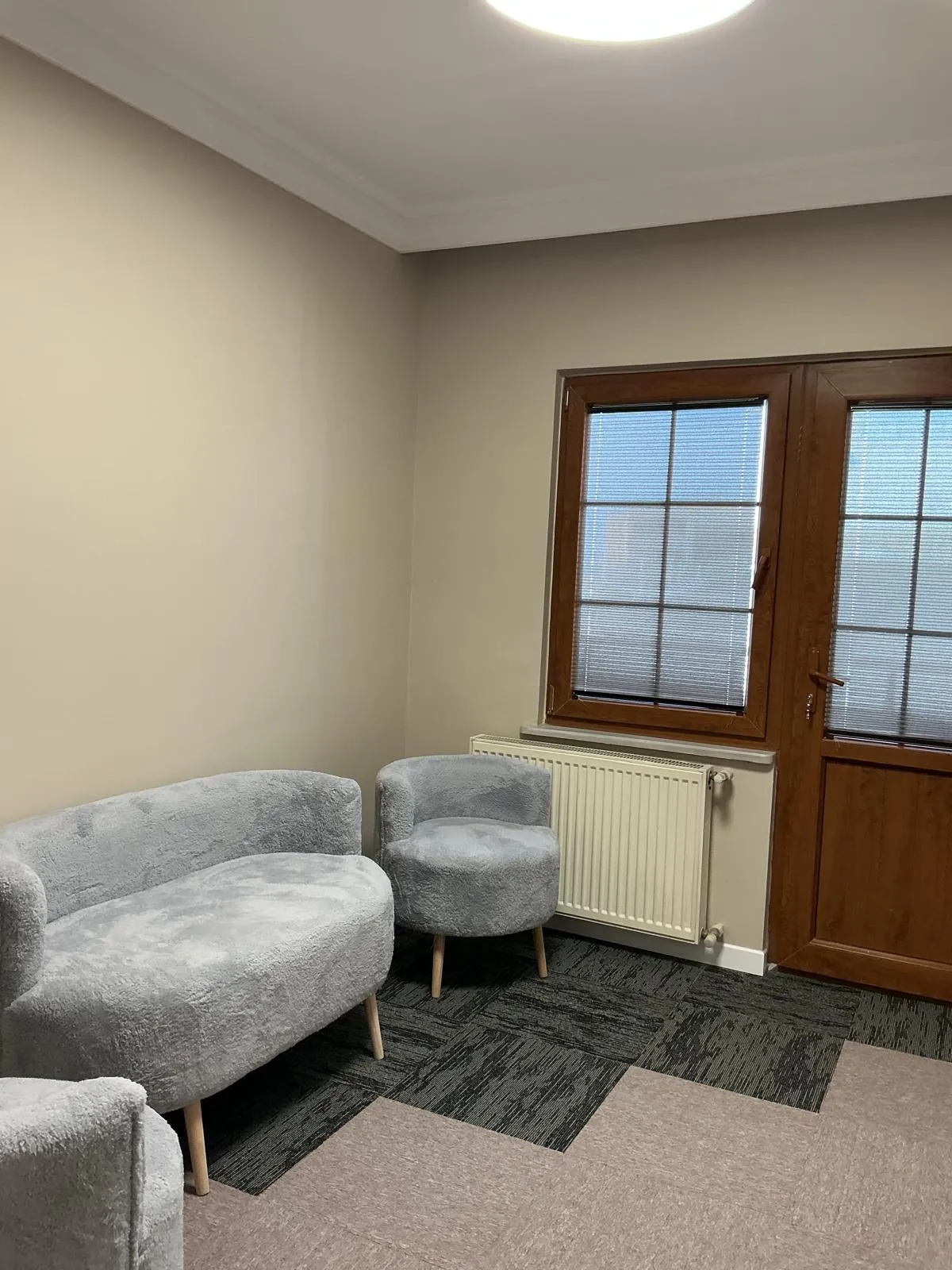 Peluş gri koltuklar ve ahşap pencereli bekleme alanı