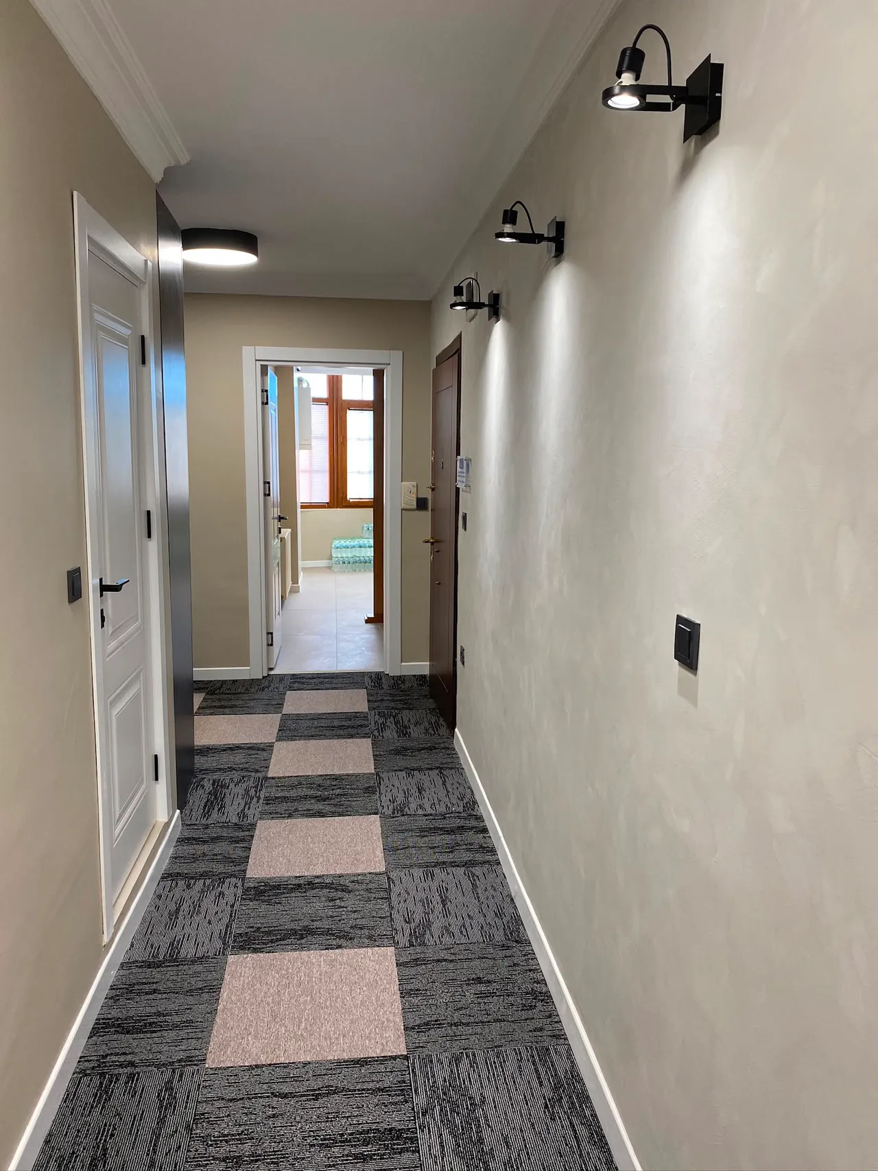 Siyah çubuk aplikler ve mikro beton duvarlı koridor aydınlatması